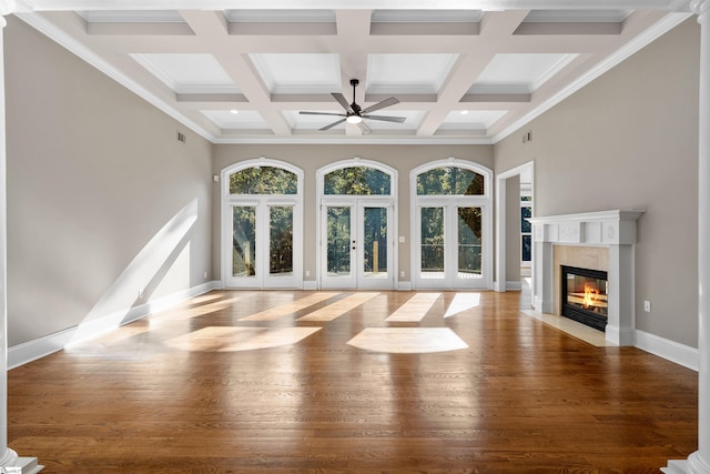 unfurnished living room with french doors, light wood-type flooring, ornamental molding, and a healthy amount of sunlight