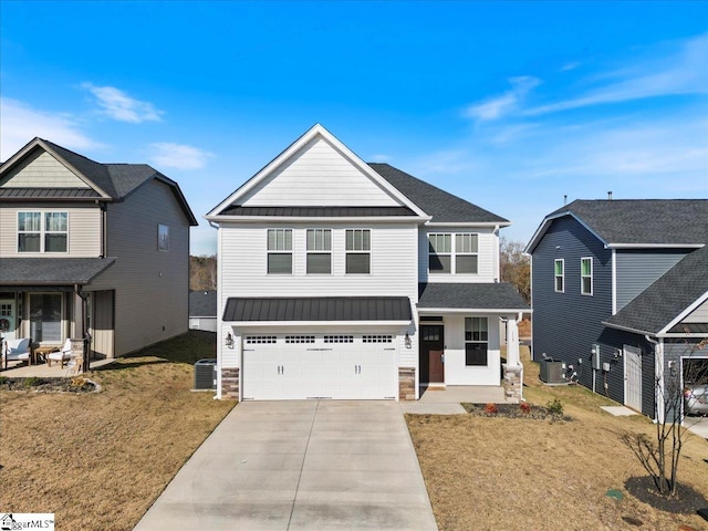 view of front of property with central AC, a front yard, and a garage