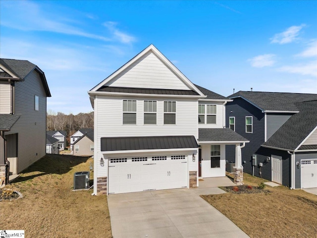 view of front of property featuring a front lawn, a garage, and central AC