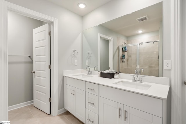 bathroom featuring vanity, tile patterned floors, and a shower with door