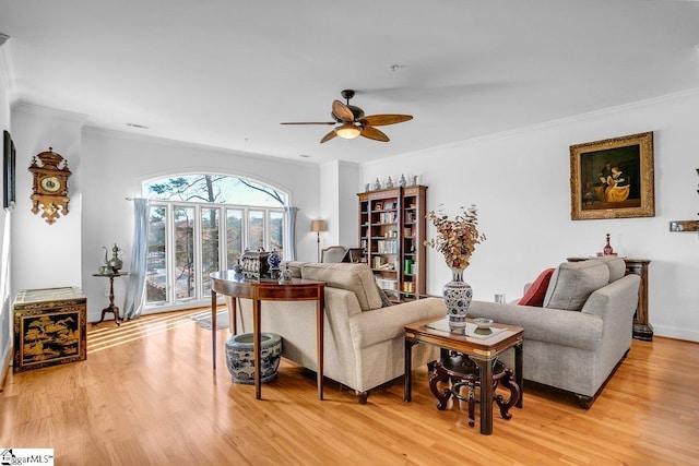 living room with ceiling fan, light wood-type flooring, and ornamental molding