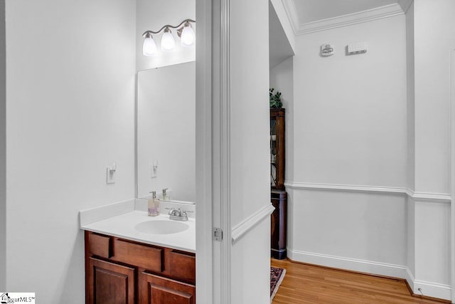 bathroom with vanity, wood-type flooring, and crown molding