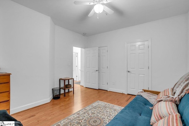 living area with ceiling fan and light hardwood / wood-style flooring