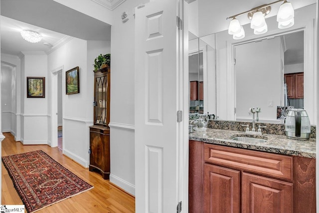 bathroom featuring hardwood / wood-style floors, vanity, and ornamental molding