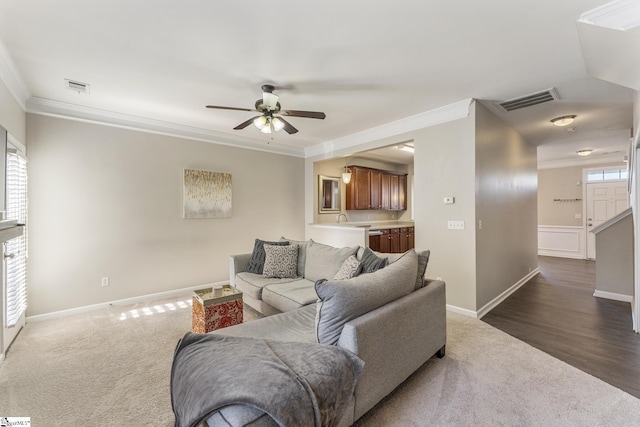 living room with ceiling fan, ornamental molding, and dark wood-type flooring