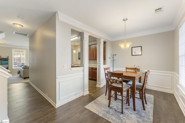 dining area featuring ornate columns, dark hardwood / wood-style flooring, and ornamental molding