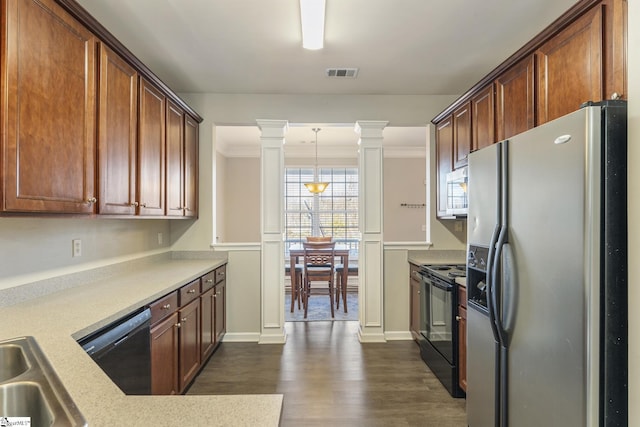 kitchen featuring dark wood-type flooring, black appliances, sink, crown molding, and ornate columns