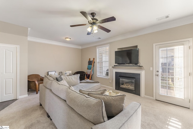 living room featuring ceiling fan, crown molding, and light carpet