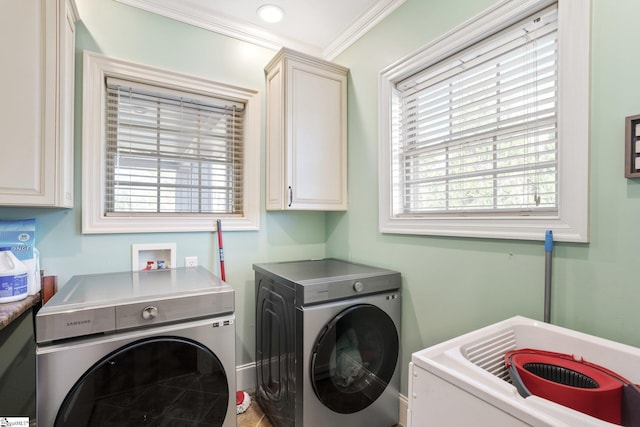 clothes washing area with ornamental molding, plenty of natural light, cabinets, and independent washer and dryer