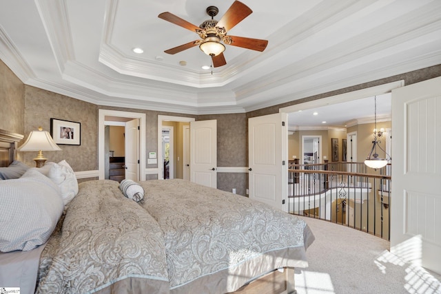 bedroom with ceiling fan with notable chandelier, a tray ceiling, and crown molding