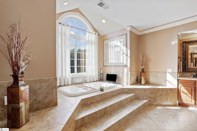 bathroom featuring vanity, a relaxing tiled tub, vaulted ceiling, and crown molding