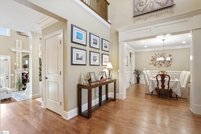 hallway with hardwood / wood-style flooring, a notable chandelier, and crown molding