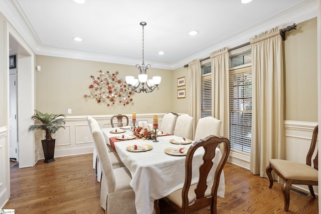 dining room with a chandelier, hardwood / wood-style flooring, and ornamental molding