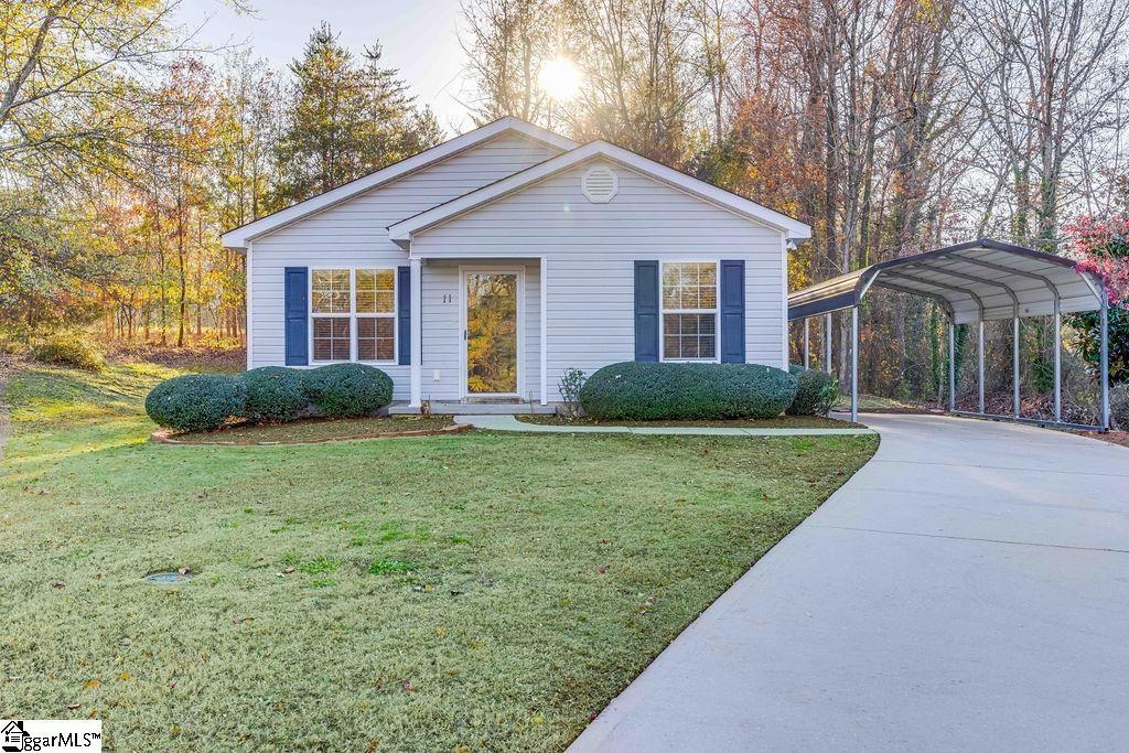 view of front of home with a carport and a front lawn