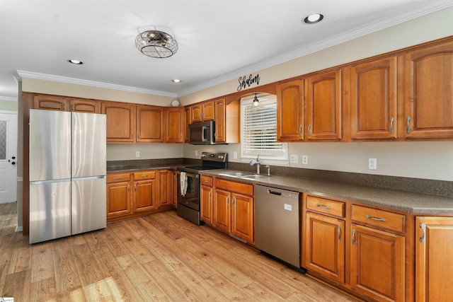 kitchen featuring crown molding, sink, stainless steel appliances, and light hardwood / wood-style flooring