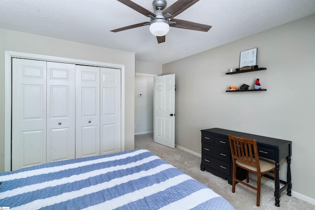 carpeted bedroom with ceiling fan, a textured ceiling, and a closet