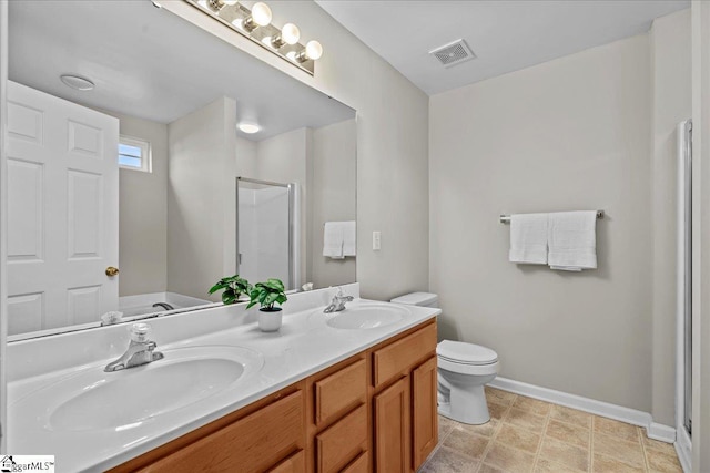 bathroom featuring vanity, toilet, and a shower with shower door