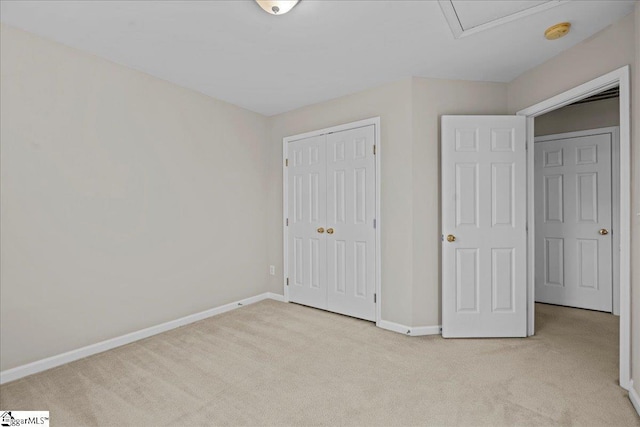 unfurnished bedroom with light colored carpet and a closet