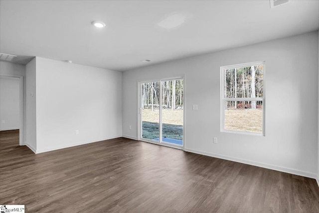 empty room featuring dark hardwood / wood-style flooring and a healthy amount of sunlight