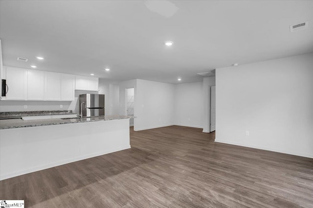 kitchen featuring light stone countertops, dark hardwood / wood-style floors, and white cabinetry