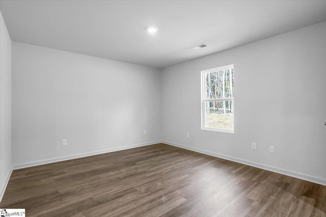 spare room with dark hardwood / wood-style floors