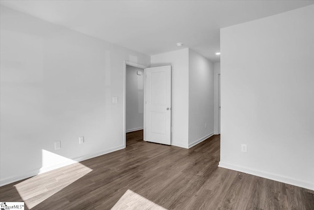 empty room with dark hardwood / wood-style flooring