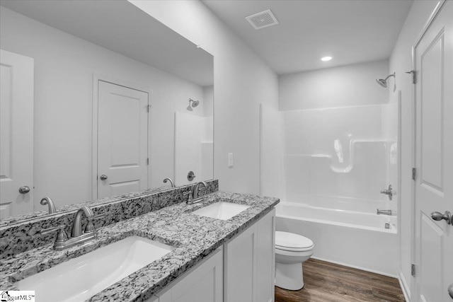 full bathroom with hardwood / wood-style floors, vanity, toilet, and washtub / shower combination