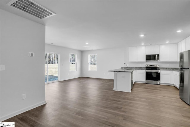 kitchen featuring sink, stainless steel appliances, kitchen peninsula, wood-type flooring, and white cabinets