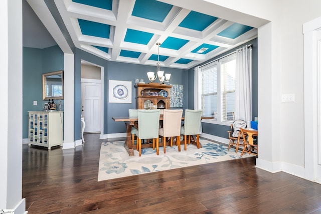 dining space featuring beam ceiling, dark wood-type flooring, coffered ceiling, and an inviting chandelier