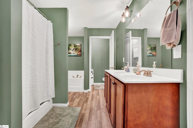 bathroom with hardwood / wood-style floors, vanity, and independent shower and bath