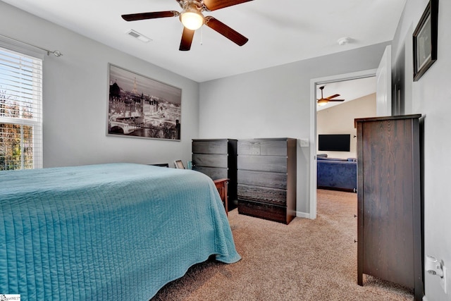 bedroom with ceiling fan, light colored carpet, and vaulted ceiling