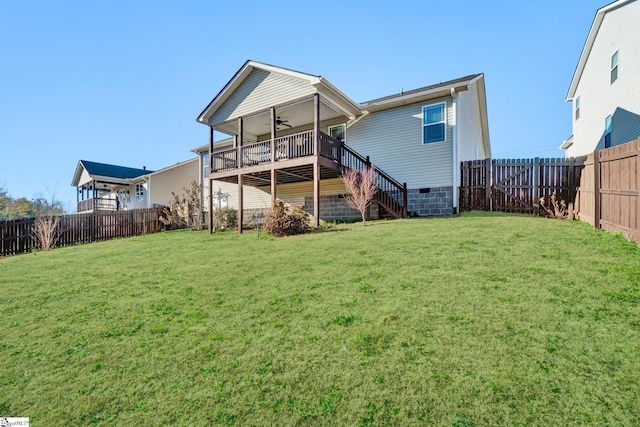 back of house with a wooden deck, ceiling fan, and a yard