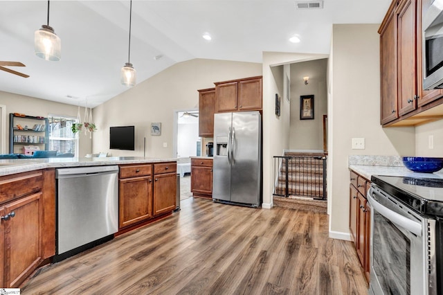 kitchen with pendant lighting, vaulted ceiling, hardwood / wood-style flooring, ceiling fan, and appliances with stainless steel finishes