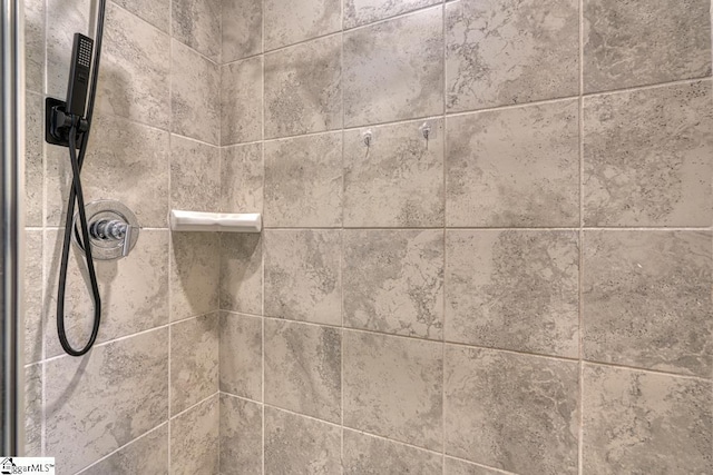 interior details featuring a tile shower