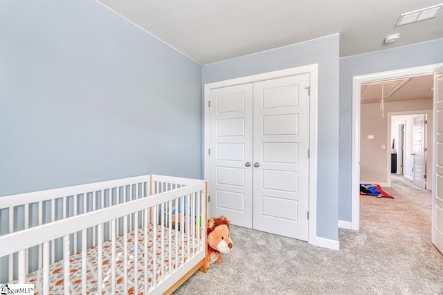 bedroom featuring a closet, light colored carpet, and a nursery area