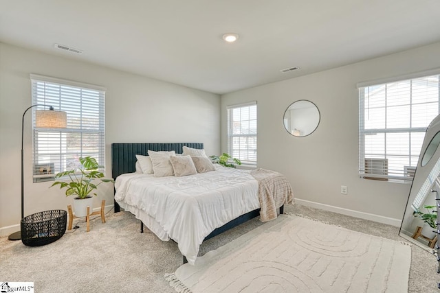 bedroom with light carpet and multiple windows