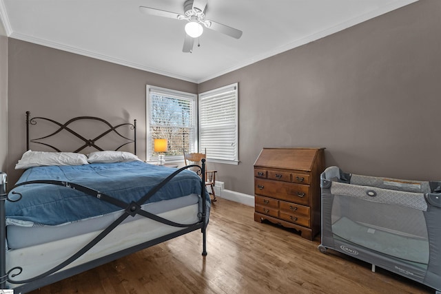 bedroom with hardwood / wood-style floors, ceiling fan, and ornamental molding