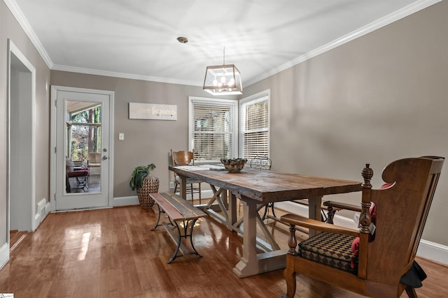 dining space with hardwood / wood-style floors and crown molding