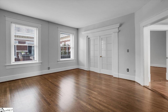 spare room featuring dark hardwood / wood-style floors and french doors