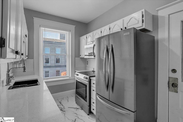 kitchen featuring white cabinetry, sink, and appliances with stainless steel finishes