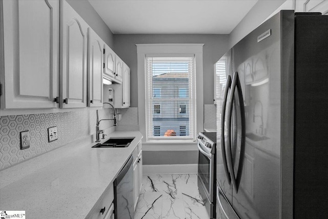 kitchen featuring decorative backsplash, sink, white cabinets, and appliances with stainless steel finishes