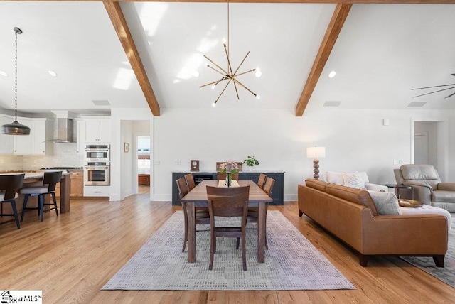 dining area featuring ceiling fan with notable chandelier, beam ceiling, and light hardwood / wood-style flooring