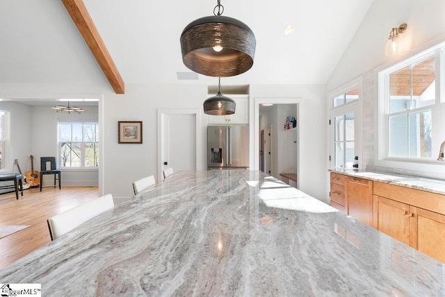 interior space featuring lofted ceiling with beams and light hardwood / wood-style flooring