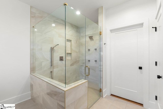 bathroom with tile patterned floors and a shower with door