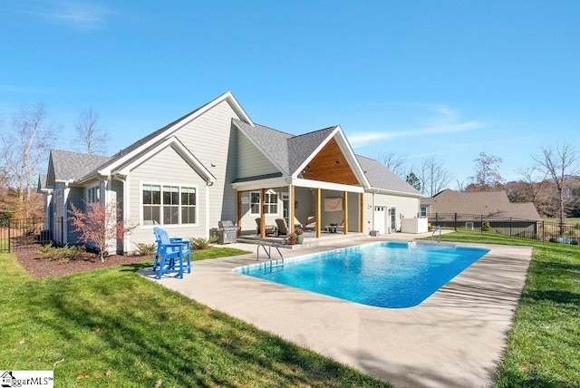 rear view of house featuring a fenced in pool, a yard, and a patio