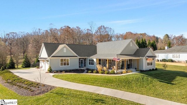 view of front of property with a porch, a garage, and a front yard