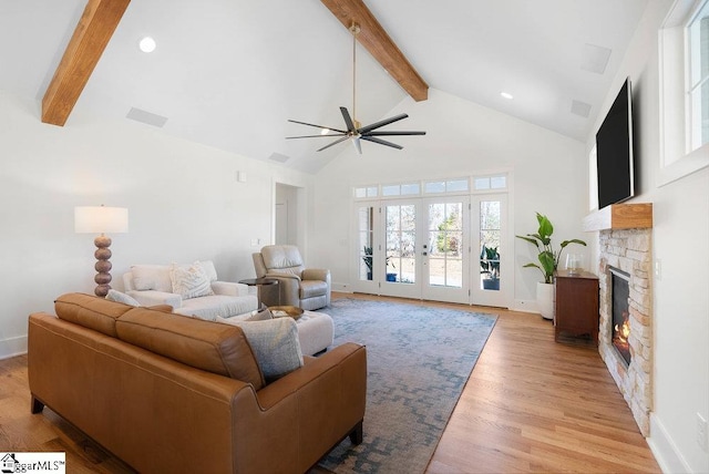 living room featuring ceiling fan, beamed ceiling, high vaulted ceiling, light hardwood / wood-style floors, and a fireplace