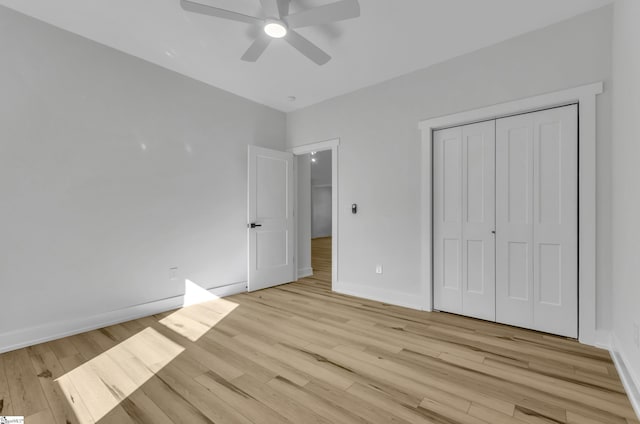 unfurnished bedroom featuring ceiling fan, light wood-type flooring, and a closet