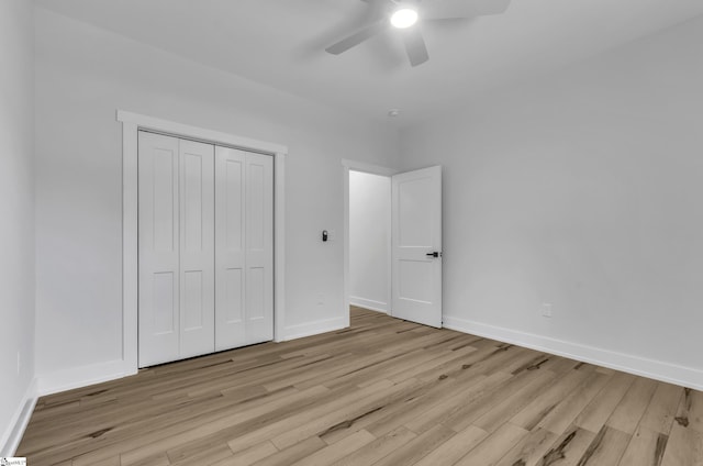 unfurnished bedroom featuring a closet, light hardwood / wood-style flooring, and ceiling fan