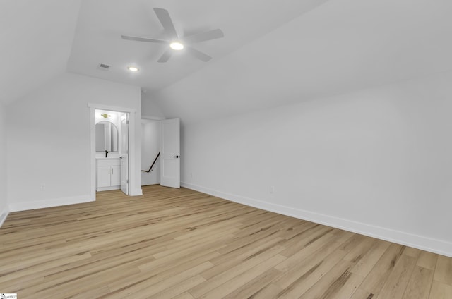 additional living space with ceiling fan, light wood-type flooring, and vaulted ceiling